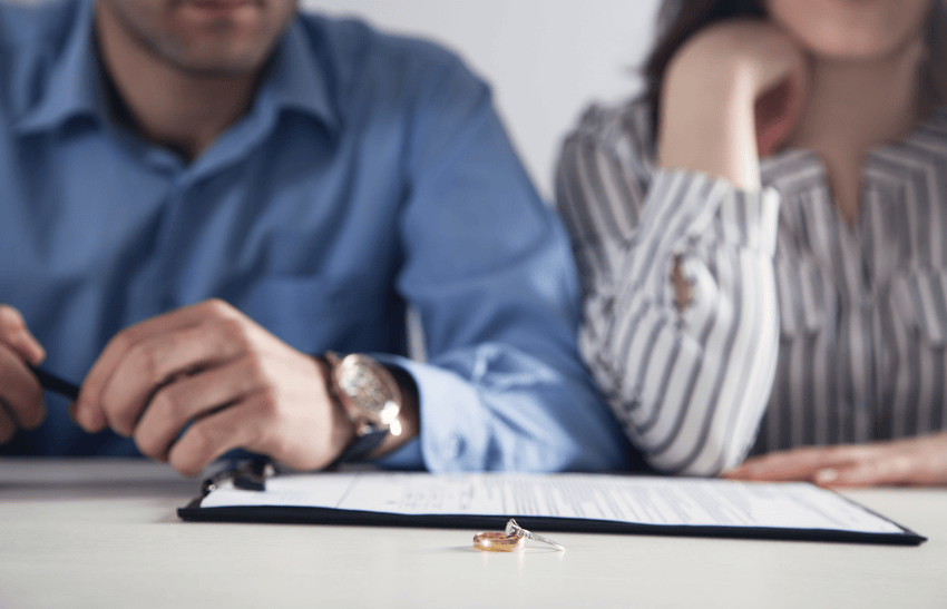 Ex spouses sitting across the table finalizing their divorce.